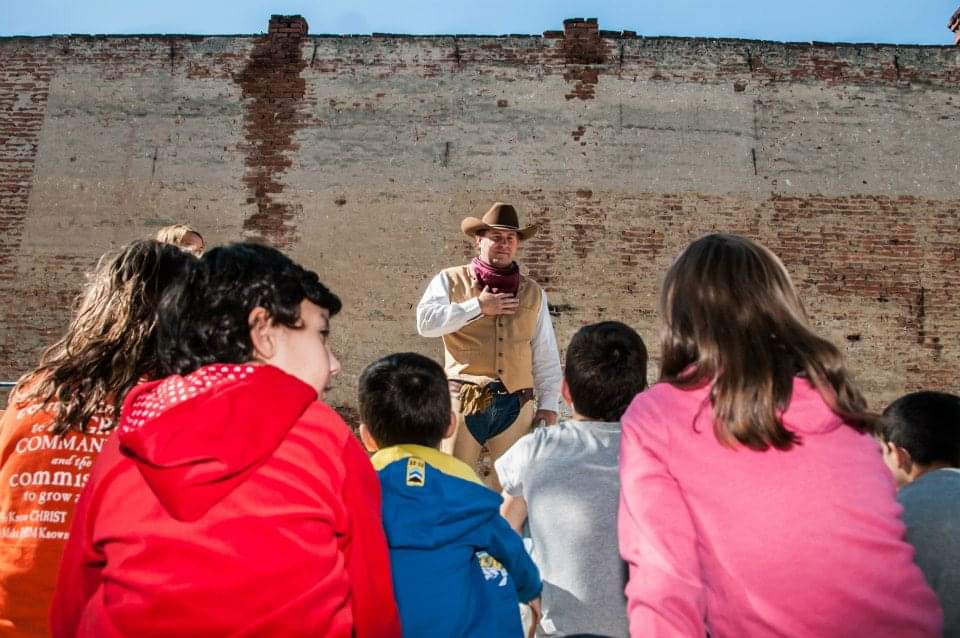 A cowboy sharing a lesson with young people